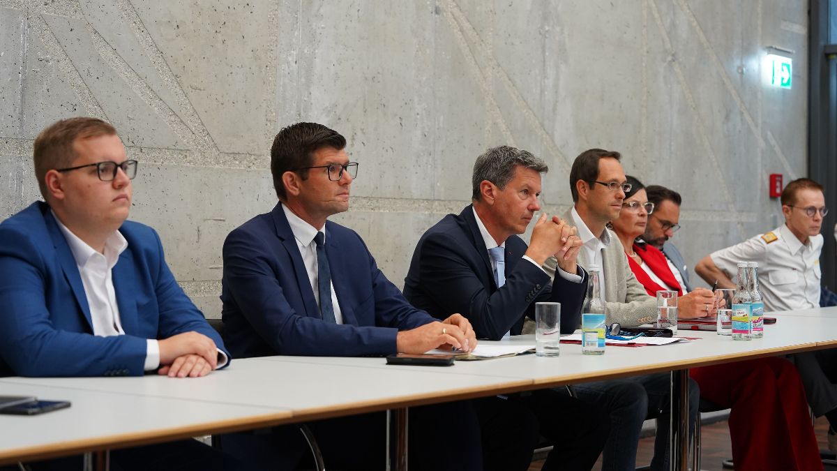 Diskussionsteilnehmer sitzen an einem Tisch in einem Konferenzraum