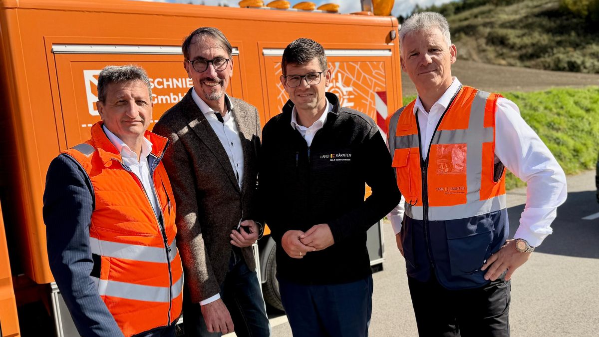Vier Männer vor orangem Fahrzeug: Martin Gruber, Peter Kaiser, Sebastian Schuschnig und ein weiterer Mann
